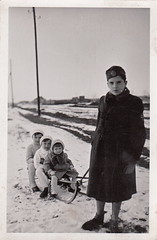 Big brother pulling a sledful of siblings through a Hungarian winter landscape (undated)